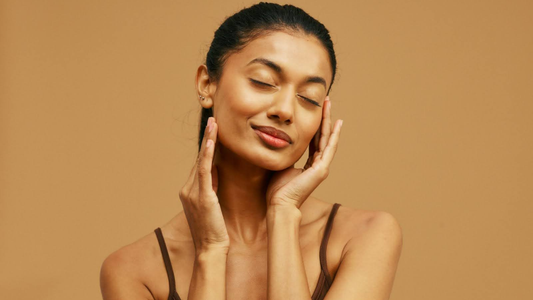Woman applying natural oil to face as part of a skincare routine.