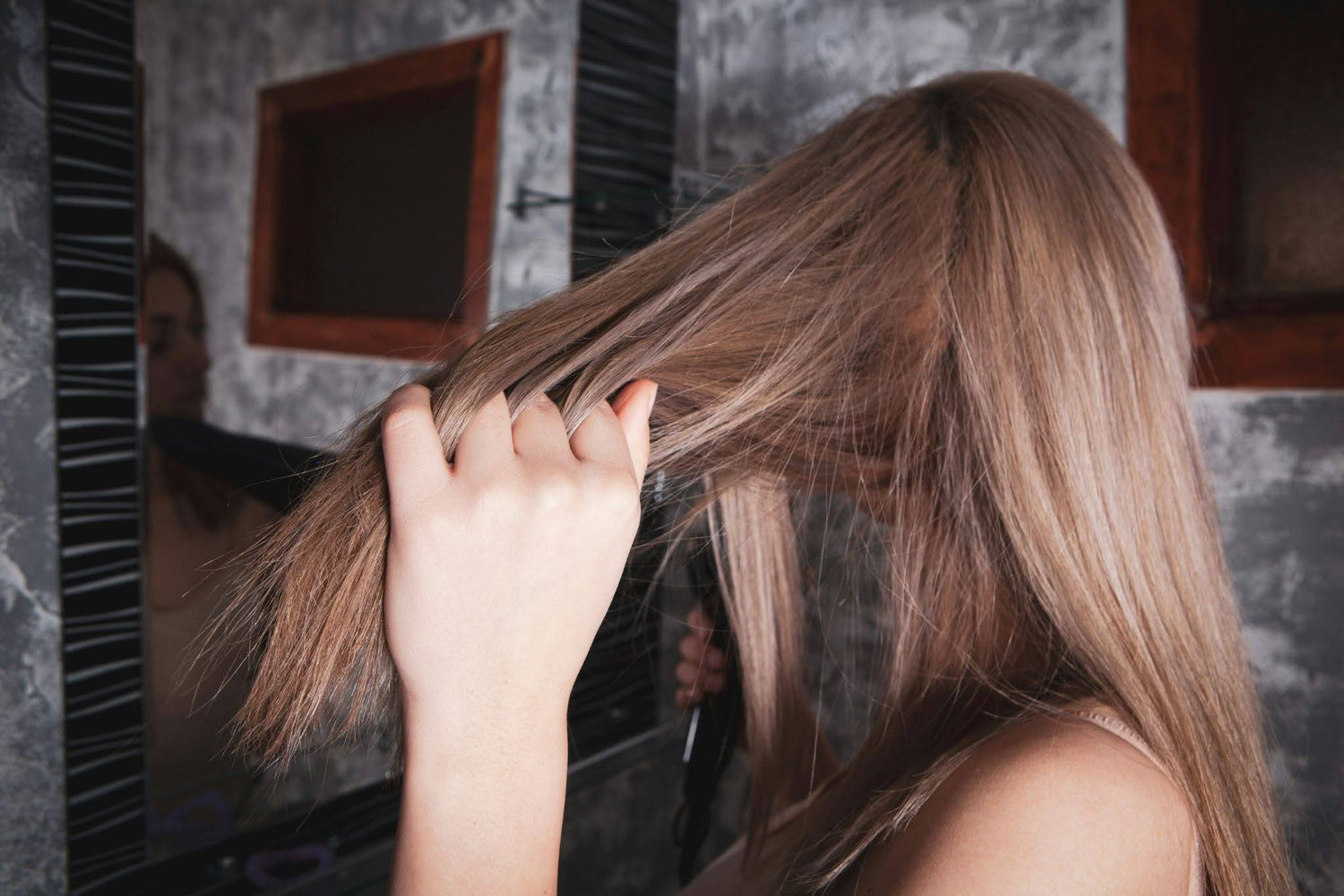 Woman doing her hair in the mirror