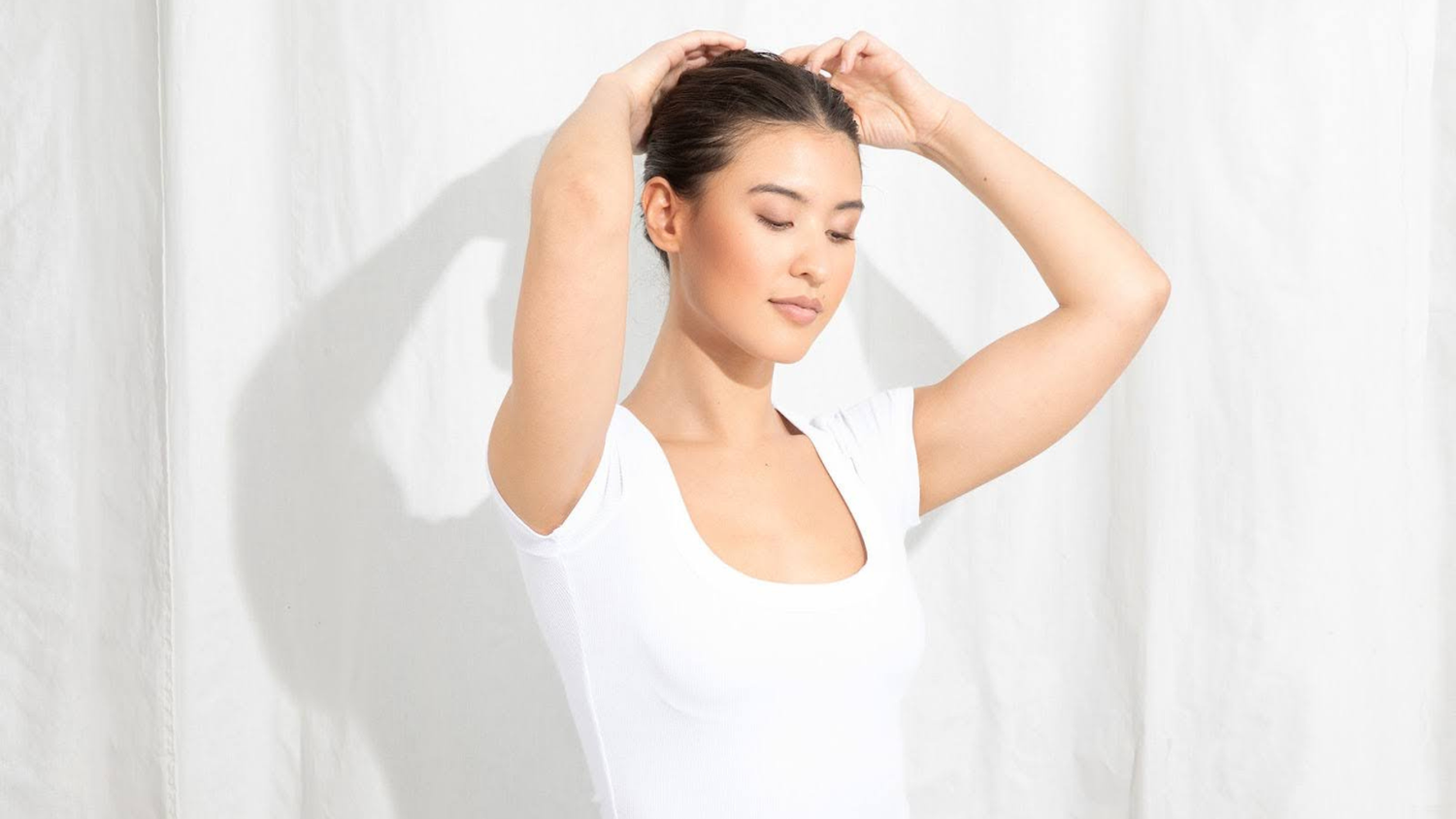 Woman gently massaging scalp while preparing to apply batana oil treatment