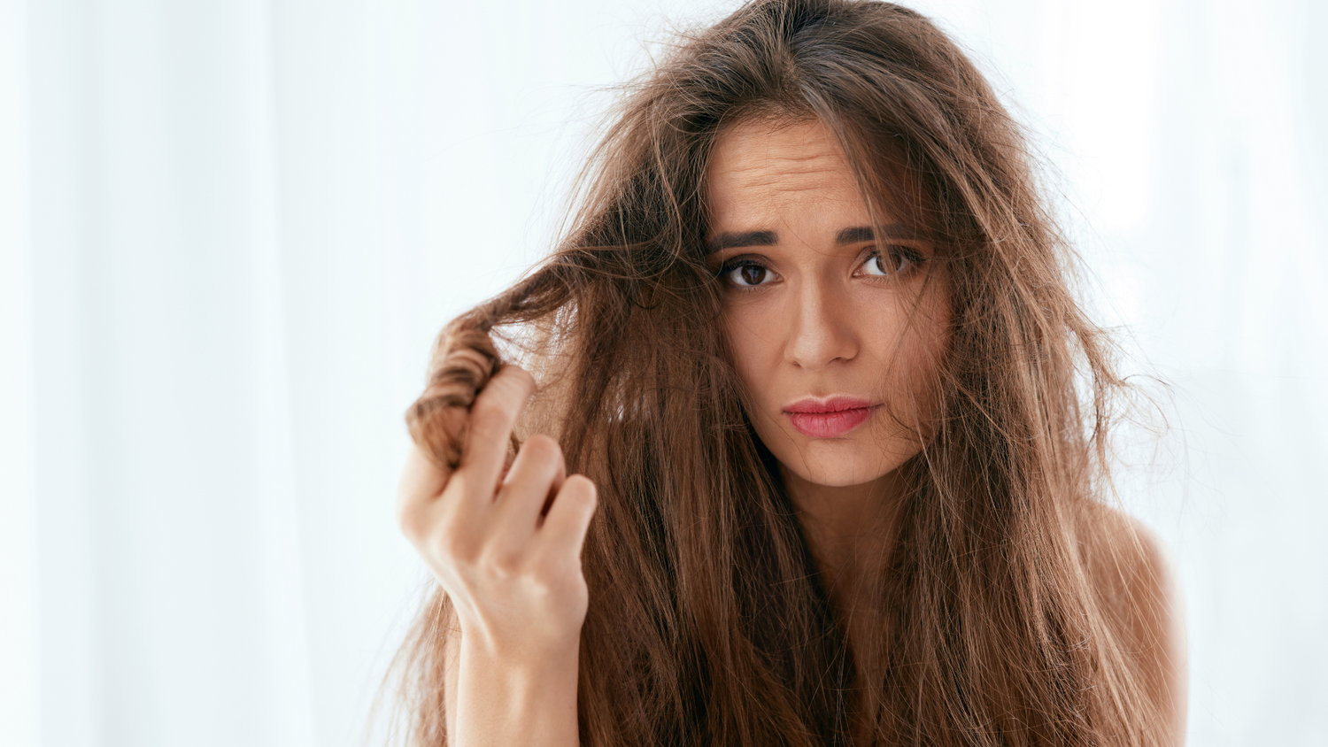 Woman with dry, frizzy hair searching for the best hair oil