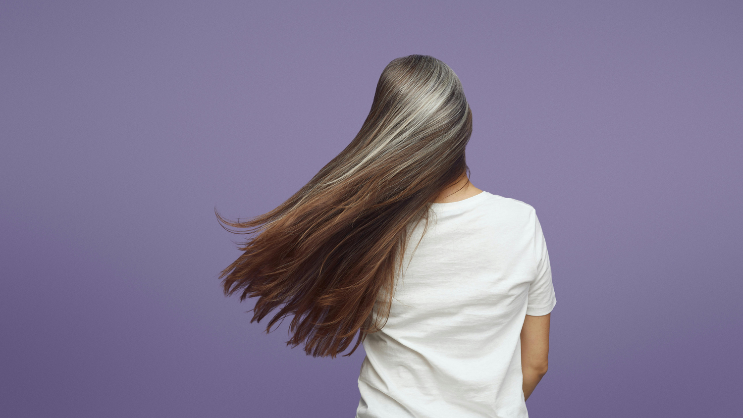 Woman with long, thick natural hair showing healthy volume and movement